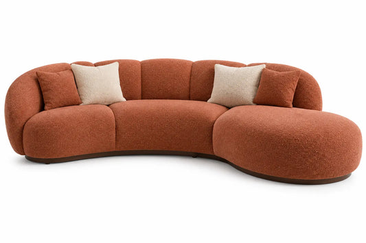Canapé terre cuite courbé avec assise prolongée et coussins clairs